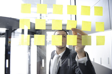 geschäftsmann arbeitet hinter scheibe mit post it
