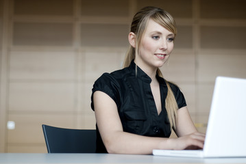 junge frau sitzt vor computer bildschirm