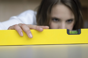 frau mit wasserwaage justiert mit auge