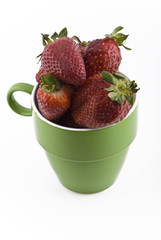 overhead view of strawberries in green mug