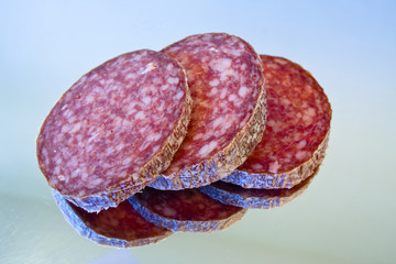 Drei Scheiben Salami auf Spiegelfläche