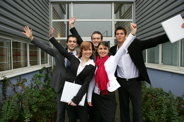 hommes et femmes souriants devant une entreprise