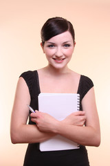 Smiling woman holding notebook and pen