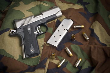 45 Firearm Pistol Clip And Hand Gun Ammunition on Camouflage