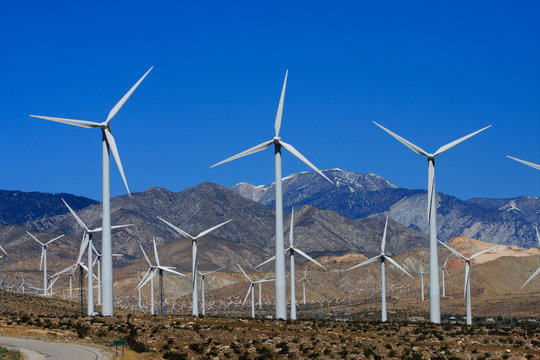 wind generators snow capped mountains blue sky