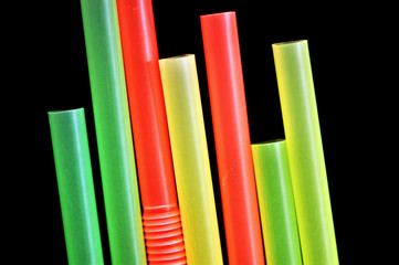 Colorful drinking straws against a black background.