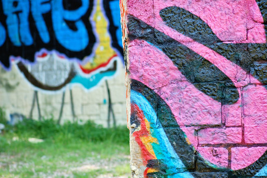 Stone wall surface covered with graffiti tags.