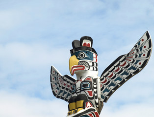 Detail of a North American Totem Pole against a blue sky