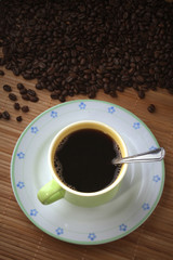 Coffee cup with coffee beans, saucer and spoon
