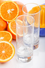 glass of orange juice with fruits near by