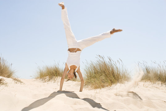 Frau macht Kopfstand in den D&uuml;nen