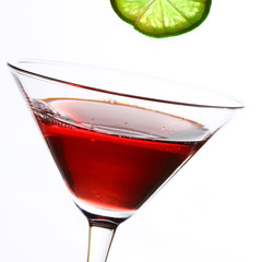 red cocktail with lime on white