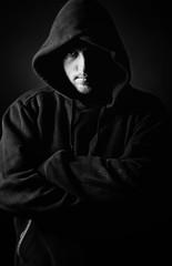 Fototapeta na wymiar Shot of a Hooded Youth against Dark Background