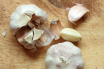 Two heads of garlic lying on wooden background