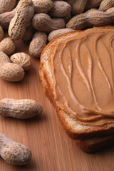 peanut butter sandwich with peanuts on cutting board