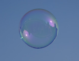 bubble blown from water and soap against a blue sky