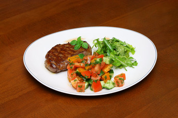 Plate with the cutlet and vegetables, salad and spices