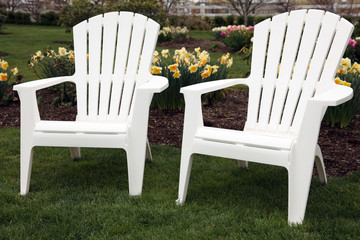 Two garden patio adirondack chairs with flowers