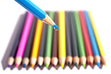 Colored pencils organized in a nice way on a while background.
