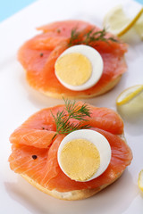 Smoked salmon on bagel with fresh black pepper and egg.