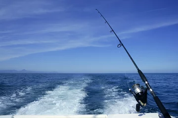 Wall murals Fishing Fishing rod and reel on boat, fishing in blue ocean