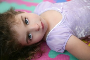 Obraz na płótnie Canvas Beautiful blue eyes little girl lying on floor