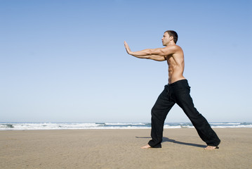 Fototapeta premium Mann meditiert am Strand