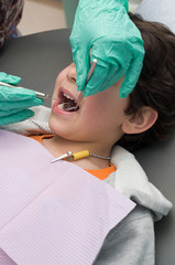 Young boy having his teeth checked and cleaned at the dentist