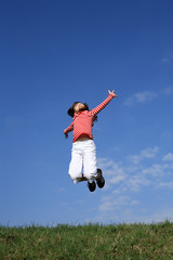 Girl jumping, running against blue sky