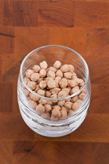 chickpeas in glass on wooden table