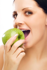 Young woman eating apple and smile over white background