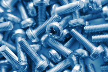 Bunch of screws as background in blue