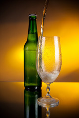 bottle of beer and beer puring into glass