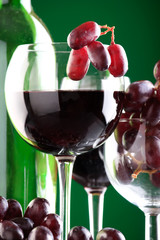 a glass of red wine and grape