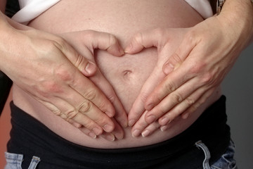 heart from hands on belly gravid women