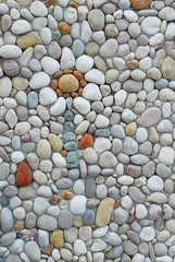 Flower shaped by pebbles in natural colors. Vertical photo with copy space.