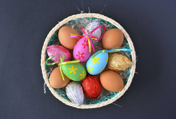 Basket with fresh and Easter eggs isolated on black