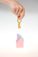 house under hand holds a gold key