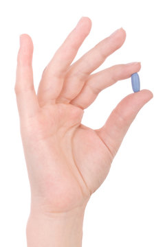 Hand Holding A Blue Pill Isolated On White.