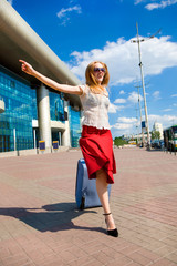Young woman, blond, runs against the backdrop of the station. In