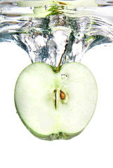 green apple dropped into water with splash isolated on white