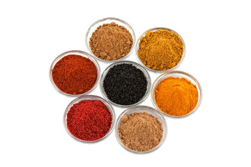 several indian spices in glass bowls