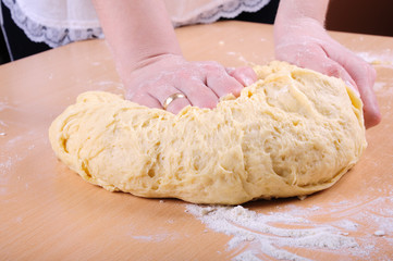 Woman kneading dough on a kitchen table