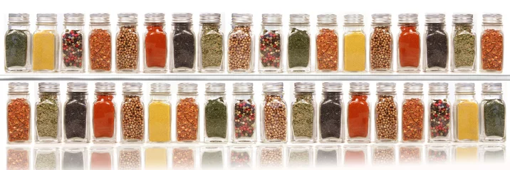 Keuken spatwand met foto Assorted spices on two layer shelves against white © Sandra Cunningham