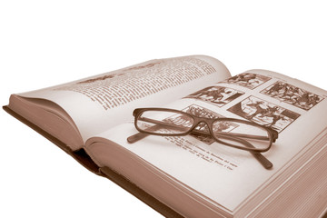 Old book and glasses on white