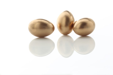 drei goldene Eier auf weissem Acryl
