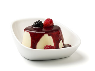 panna cotta with berry fruit sauce in bowl isolated