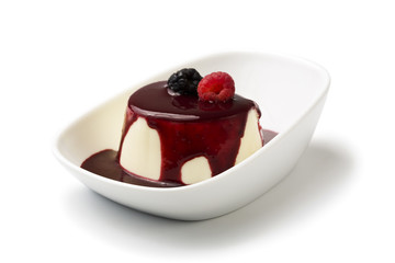 panna cotta with berry fruit sauce in bowl isolated