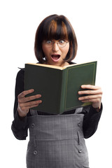 Shocked brunette schoolgirl looking in the book