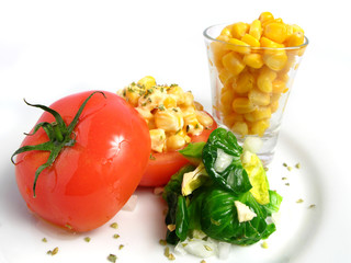 Tomato Stuffed with corn and mayonnaise on white dish